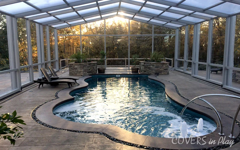 Sunset view of residential pool dome enclosure in Des Moines, IA, surrounded by trees